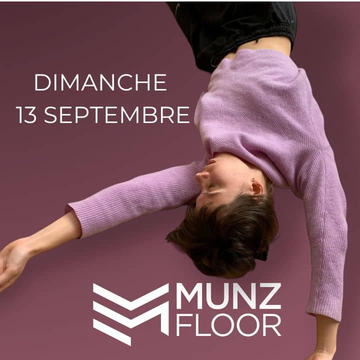 Femme suspendue en pull violet, fond mauve